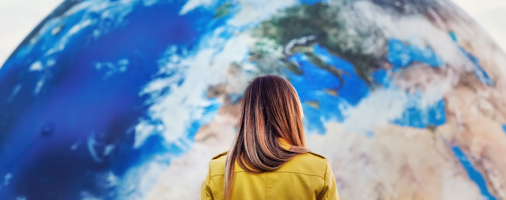 Woman staring at a large world map on a wall